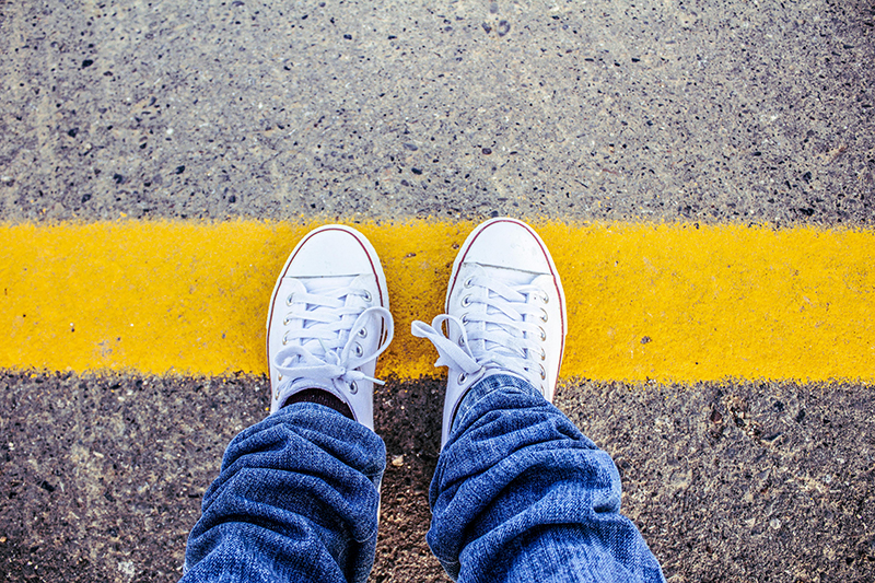 converse shoes standing on a yellow line in the road illustrating How Narcissists React to Boundaries